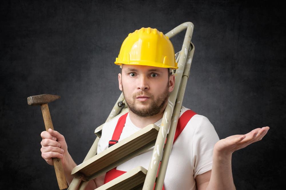 Clumsy worker standing with ladder and hammer