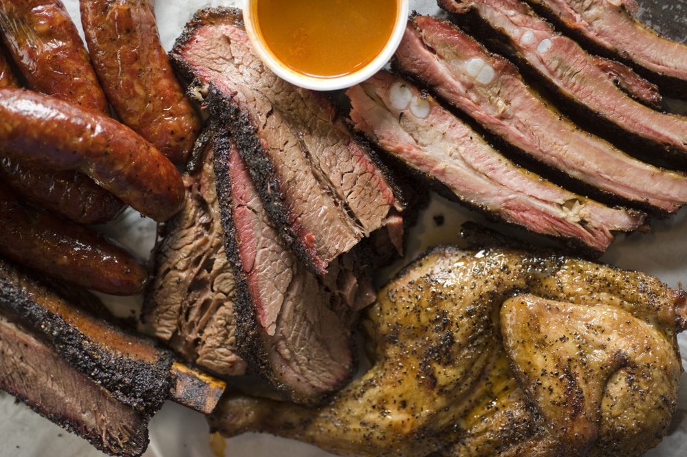 Barbecue catering platter with variety of meats. Traditional Texas BBQ: Beef brisket, beef ribs, pork ribs, sausage links, black pepper roasted chicken, and turkey served with homemade sauce
